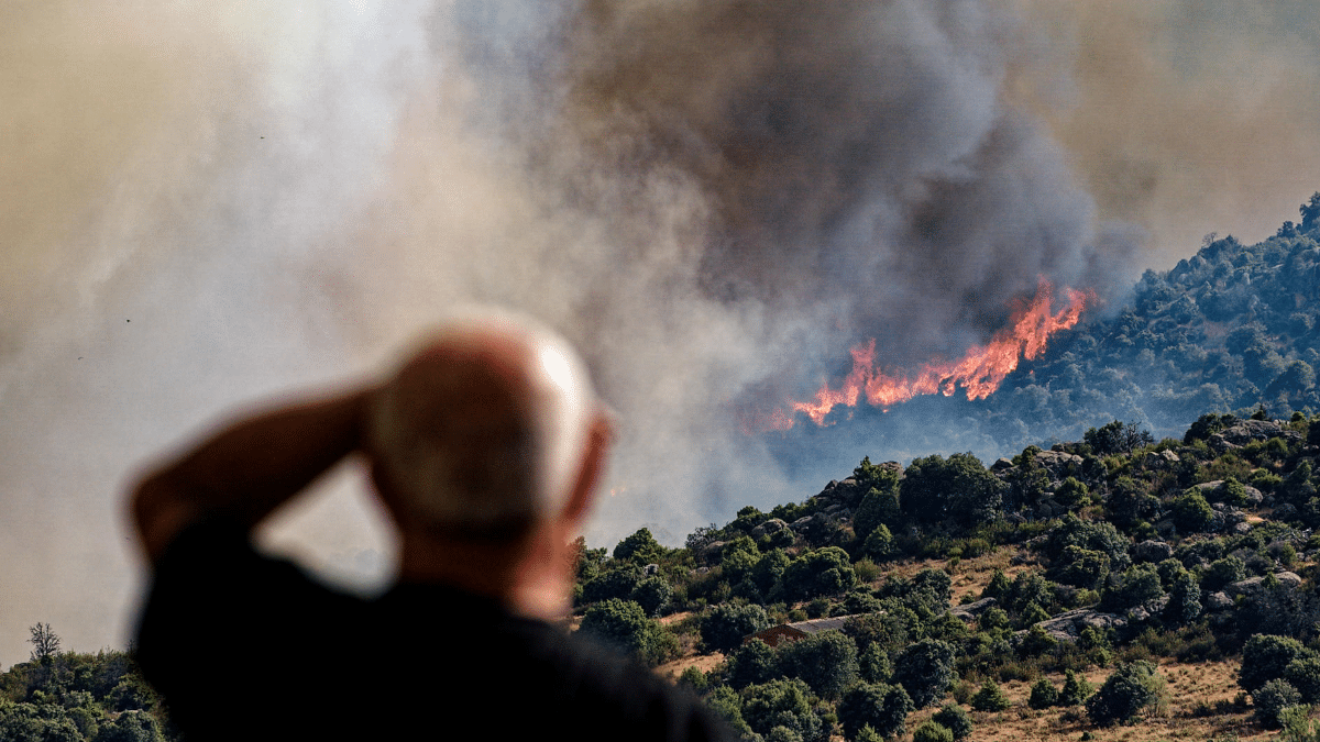 Un hombre contempla este viernes la evolución del incendio de Navaluenga.