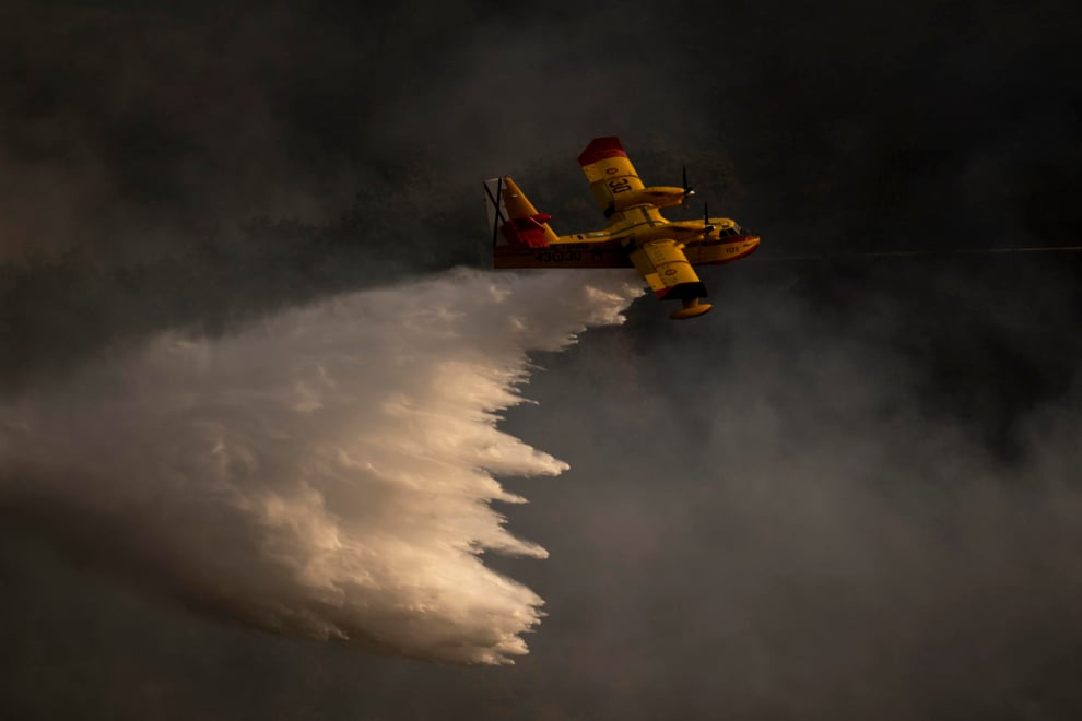 Un hidroavión realiza labores de extinción este domingo en el incendio forestal que permanece activo en la localidad de Maceda (Ourense). 