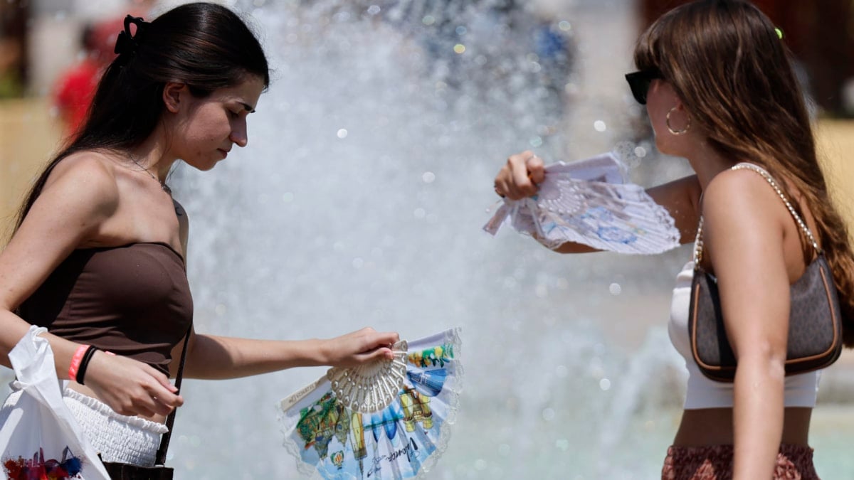 Dos mujeres se refrescan este martes en el centro de Valencia.