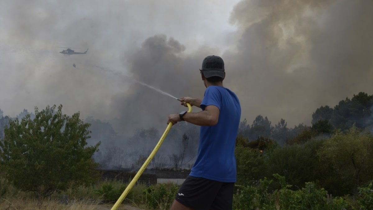 Una persona colabora en la extinción del incendio, a 12 de agosto de 2025, en Seixalbo, Ourense, Galicia (España).