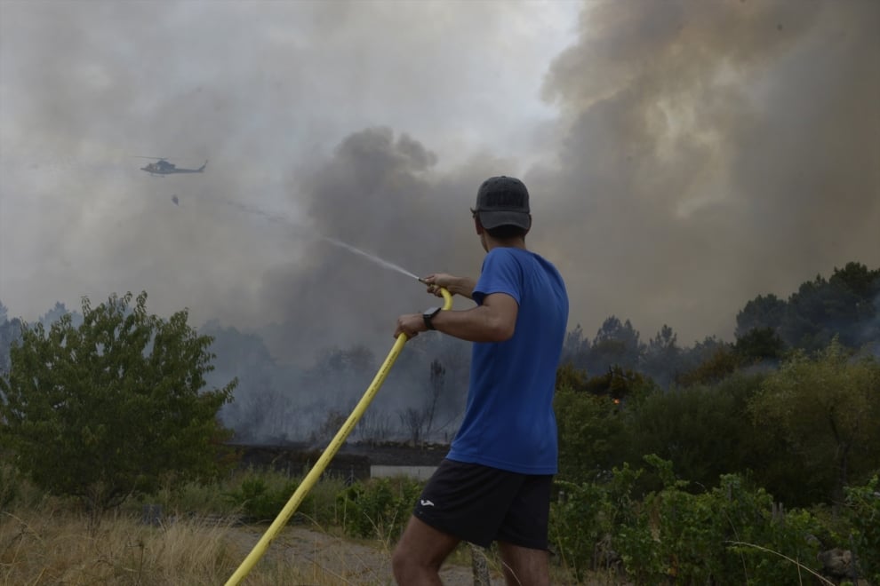 Una persona colabora en la extinción del incendio, a 12 de agosto de 2025, en Seixalbo, Ourense, Galicia (España). 
