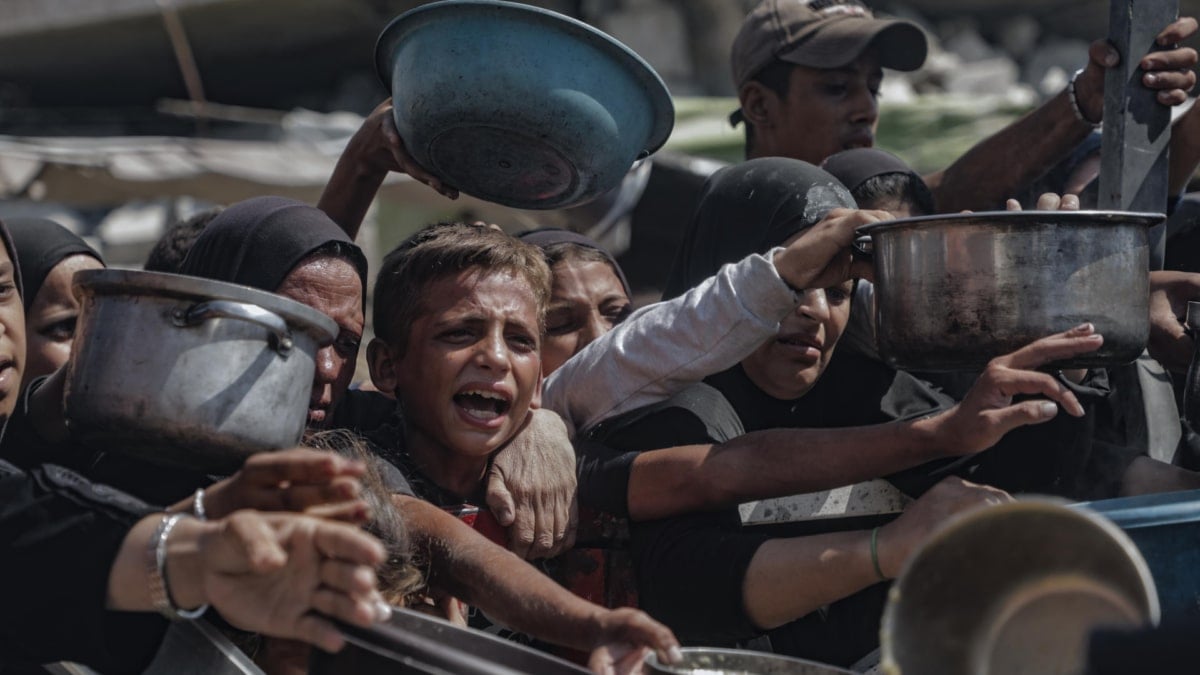 Varios niños tratan de conseguir comida en los centros de distribución de alimentos en la Franja de Gaza