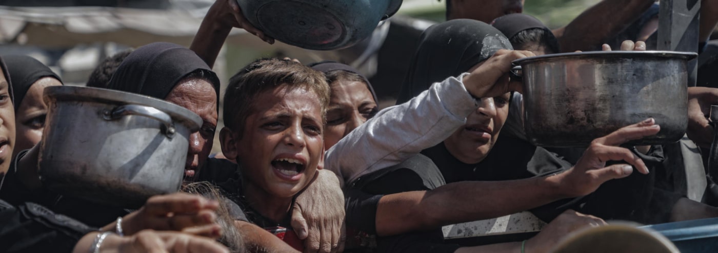 Varios niños tratan de conseguir comida en los centros de distribución de alimentos en la Franja de Gaza