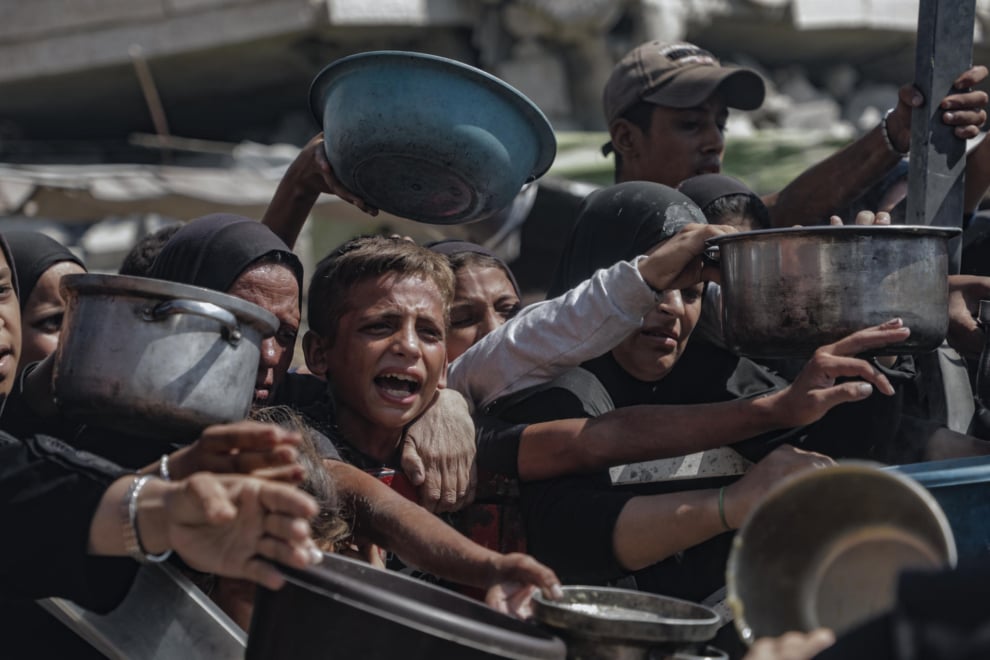 Varios niños tratan de conseguir comida en los centros de distribución de alimentos en la Franja de Gaza