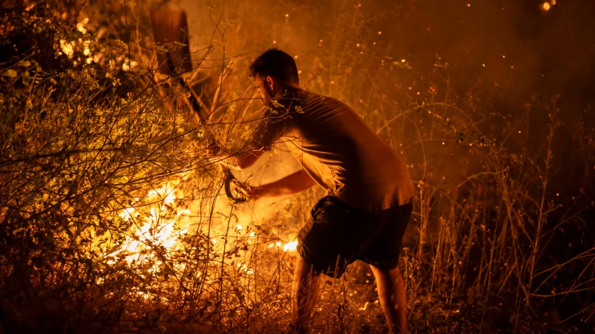 Un vecino trabaja la madrugada del pasado domingo en labores de extinción del incendio forestal de A Rúa (Ourense).