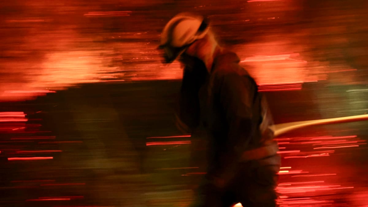Bomberos forestales ante las grandes llamas del incendio en Aguasmestas, una parroquia del municipio de Quiroga, en la provincia de Lugo.