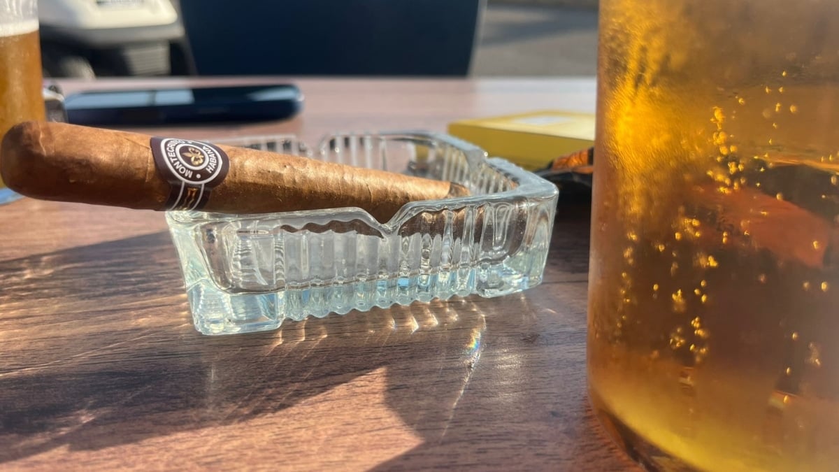 Puro habano junto a un vaso de cerveza en una terraza de la costa andaluza.