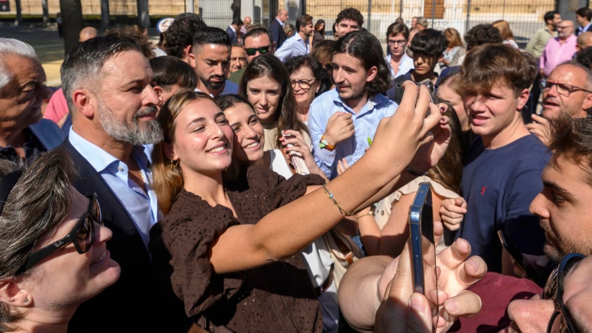 El presidente de Vox, Santiago Abascal, atiende a varios jóvenes en Sevilla, tras una comparecencia de prensa reciente