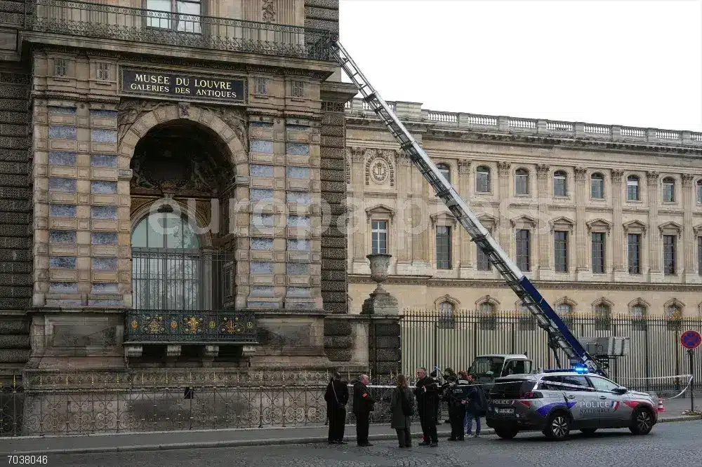 Policías junto al lugar por donde entraron los ladrones al Louvre.