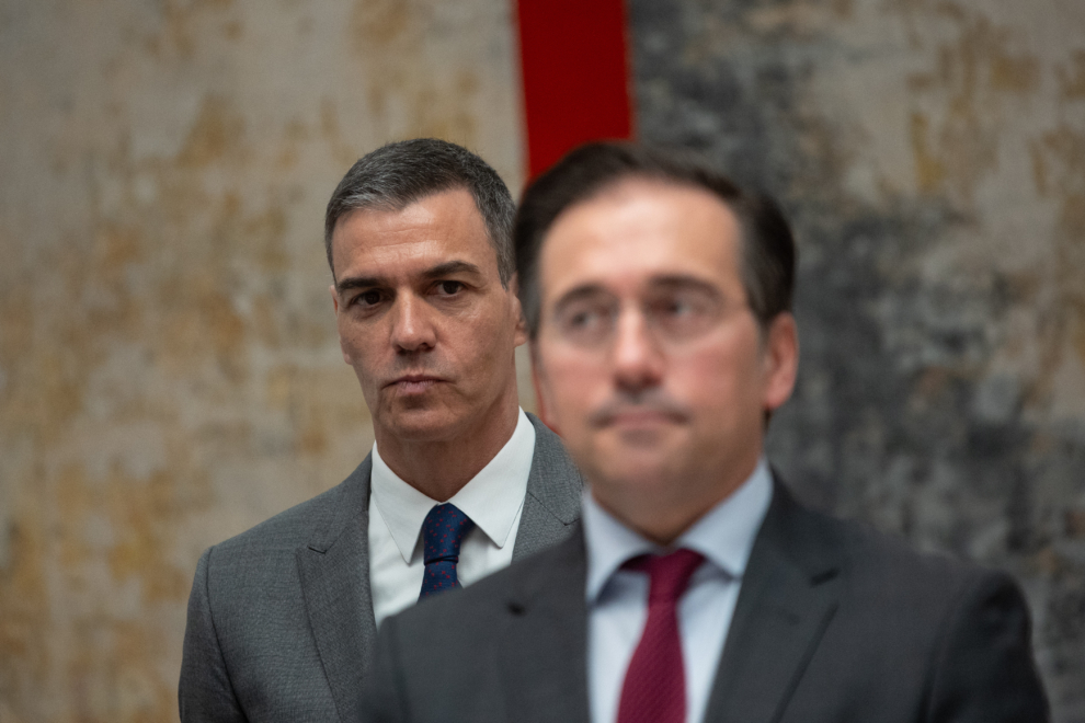 El presidente del Gobierno, Pedro Sánchez, en segundo plano, mira al ministro de Exteriores, José Manuel Albares, en Moncloa.