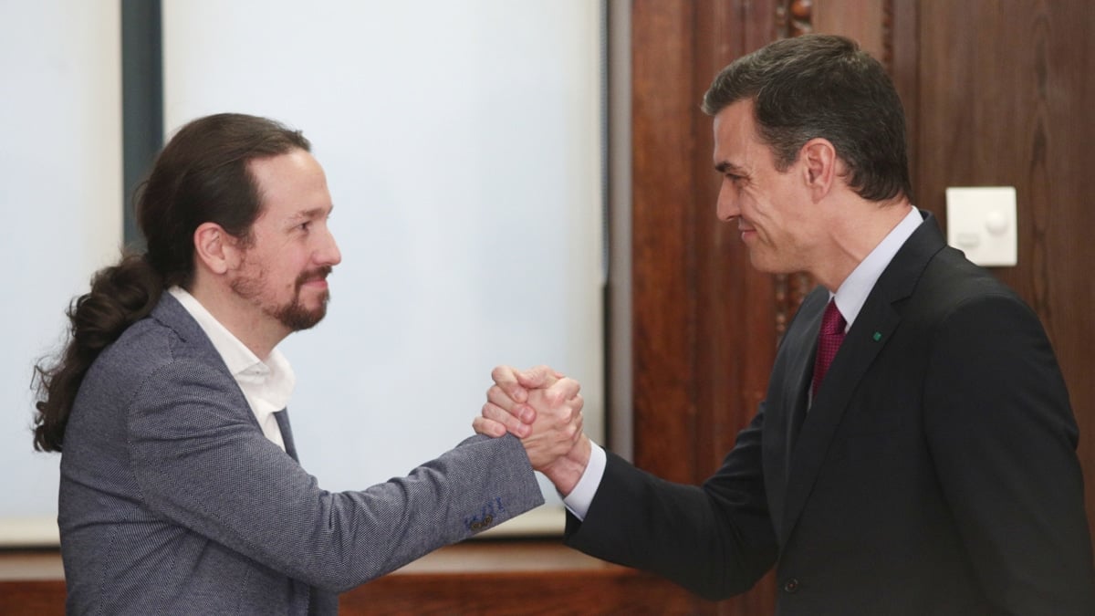 Pedro Sánchez y Pablo Iglesias se dan la mano durante el acto de presentación del programa de Gobierno del PSOE y Unidas Podemos, a 30 de diciembre de 2019.