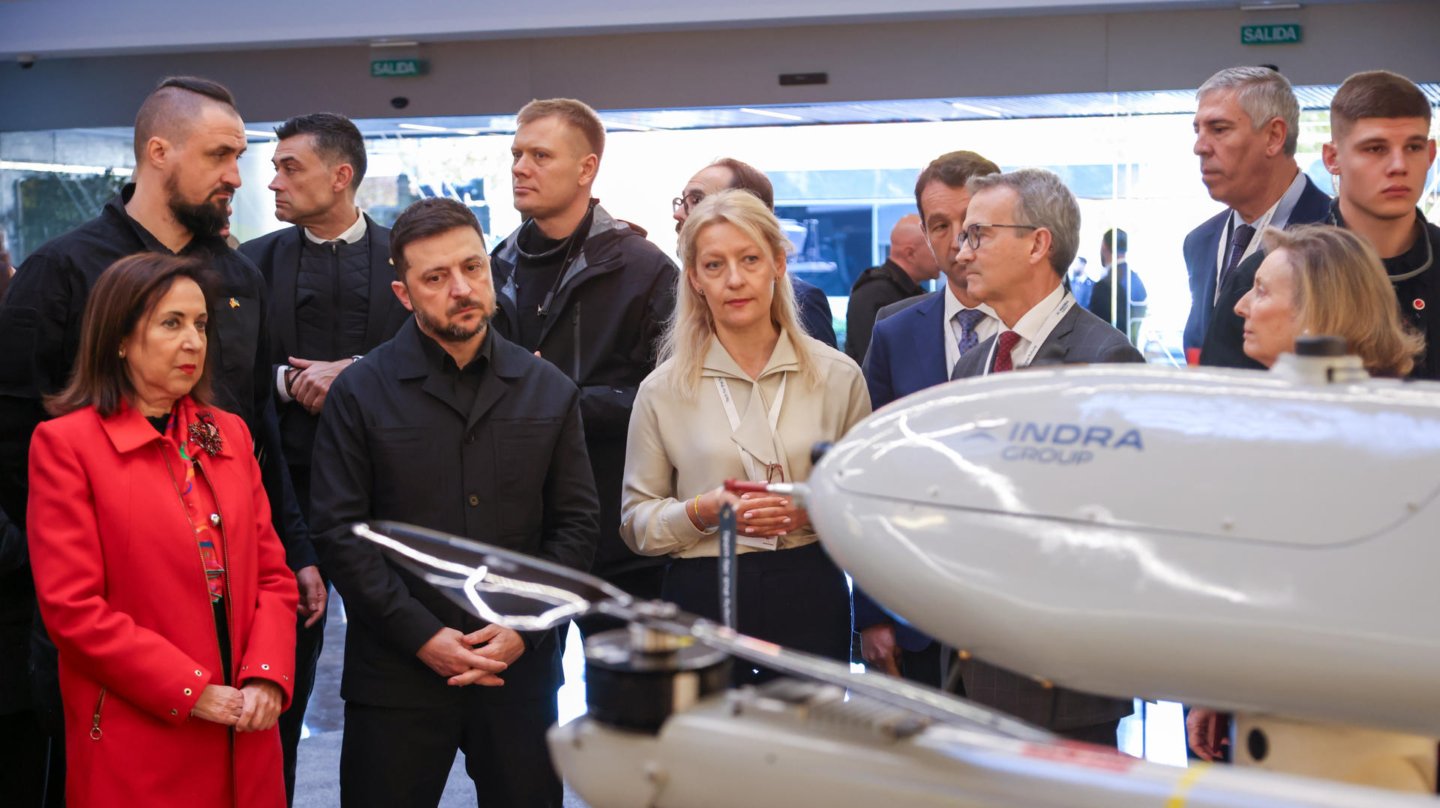 Zelenski acompañado por la ministra de Defensa, Margarita Robles (i), la secretaria de Estado de Defensa, Amparo Valcarce (d), y el presidente de Indra, Angel Escribano (3d), durante su visita a la sede de Indra.