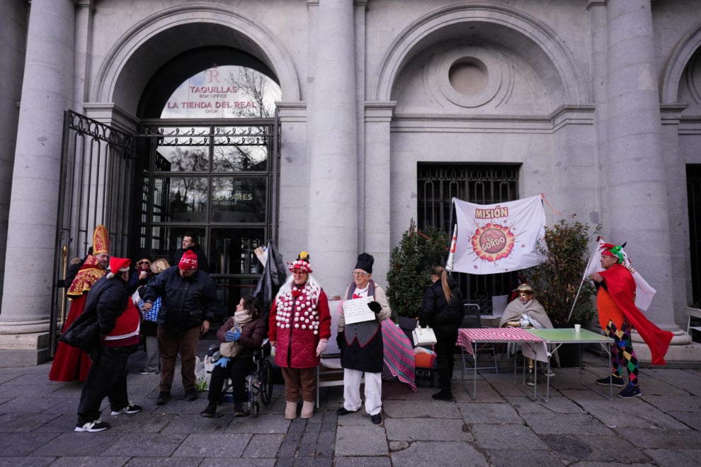 Varias personas esperan ya a las puertas del Teatro Real, este domingo, para asistir al sorteo de Navidad de El Gordo que se celebra este lunes en Madrid. EFE/ Borja Sánchez-trillo
