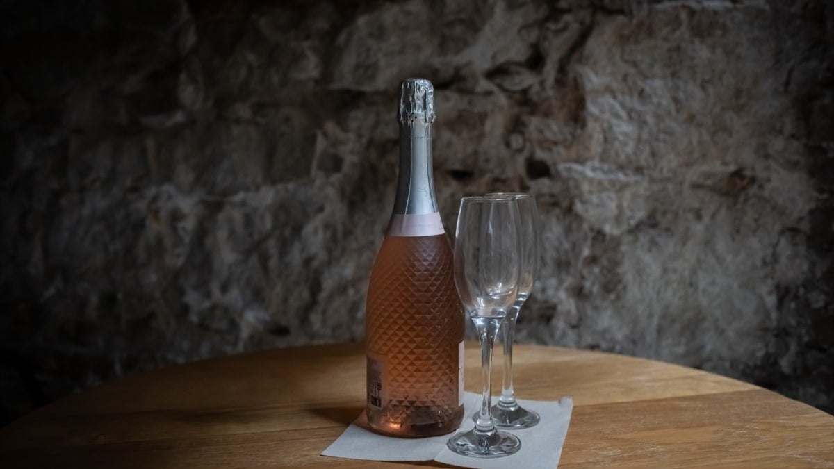 Botella de cava con dos copas