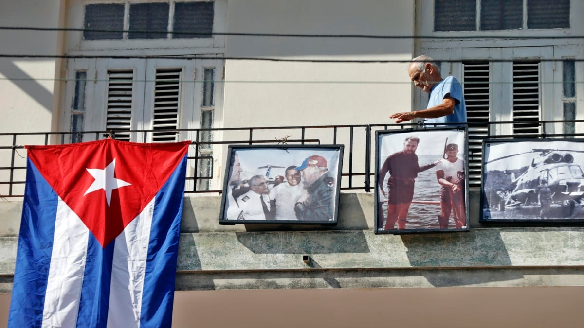Un cubano pasa cerca de retratos de Fidel Castro y Hugo Chávez en La Habana