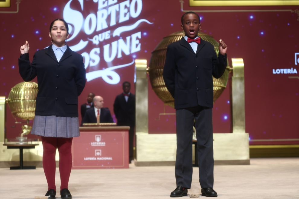 Dos niños del Colegio de San Ildefonso, cantan el 70048 segundo premio de la Lotería de Navidad, durante la celebración del Sorteo Extraordinario de la Lotería de Navidad 2025, en el Teatro Real, a 22 de diciembre de 2025, en Madrid (España). El Sorteo Extraordinario de la Lotería de Navidad de 2025 consta de 198 series y cada serie tiene 100.000 billetes. El total de la emisión asciende a 3.960 millones de euros y se destina a premios (70% de la emisión) 2.772 millones de euros. Cada serie distribuye en premios 14 millones de euros y en total se reparten 30.301.920 premios durante un sorteo que tiene una duración aproximada de cuatro horas.
Eduardo Parra / Europa Press
22/12/2025