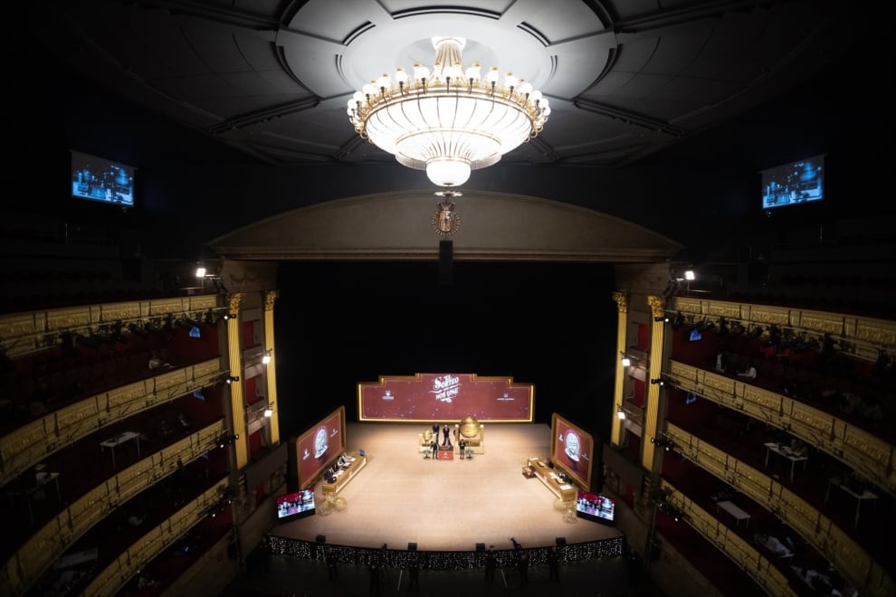 Varias personas ven como los niños del Colegio de San Idefonso cantan los números premiados durante la celebración del Sorteo Extraordinario de la Lotería de Navidad 2025, en el Teatro Real, a 22 de diciembre de 2025, en Madrid (España). El Sorteo Extraordinario de la Lotería de Navidad de 2025 consta de 198 series y cada serie tiene 100.000 billetes. El total de la emisión asciende a 3.960 millones de euros y se destina a premios (70% de la emisión) 2.772 millones de euros. Cada serie distribuye en premios 14 millones de euros y en total se reparten 30.301.920 premios durante un sorteo que tiene una duración aproximada de cuatro horas.
Eduardo Parra / Europa Press
22/12/2025