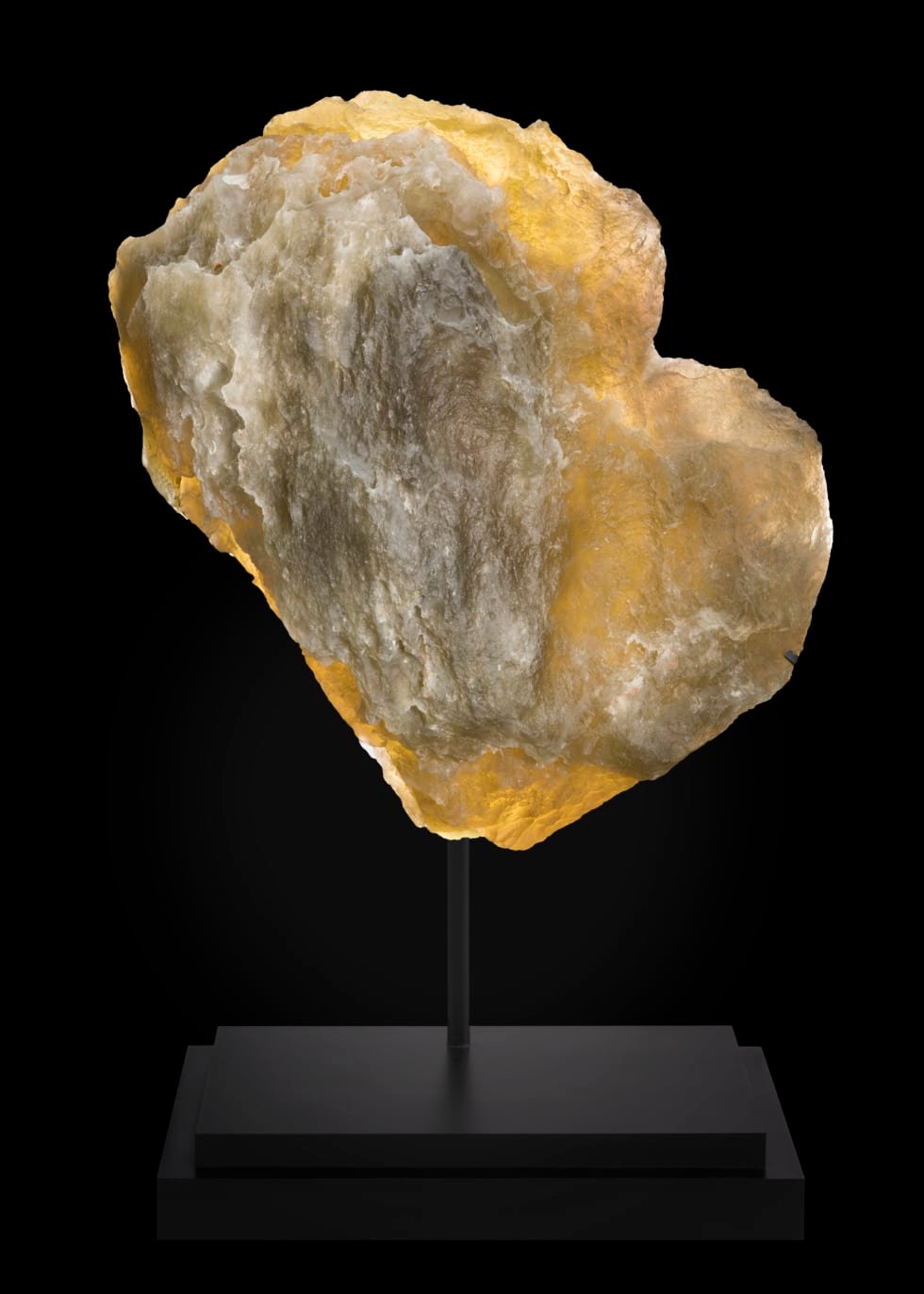 Es el mayor fragmento documentado de cristal líbico del desierto, de más de 26 kilos de peso. Se trata de vidrio natural formado hace unos 29 millones de años cuando el impacto de un asteroide o cometa fundió la arena entre la actual Libia y Egipto. Con un contenido de sílice cercano al 98%, presenta un tono amarillo solar y una translucidez sorprendente para su tamaño, con texturas que recuerdan al vidrio en ebullición tras el choque. Este material —clasificado dentro de los tektites o vidrios de impacto— requiere temperaturas superiores a 1.600 °C, muy por encima de cualquier flujo volcánico terrestre. Se usó en herramientas y joyería del periodo faraónico, incluida la tumba de Tutankamón. Se estima que pueda alcanzar los 200.000 dólares (algo más de 180.000 euros).