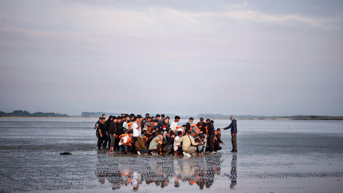 Un grupo de personas espera una lancha para cruzar el canal de La Mancha.