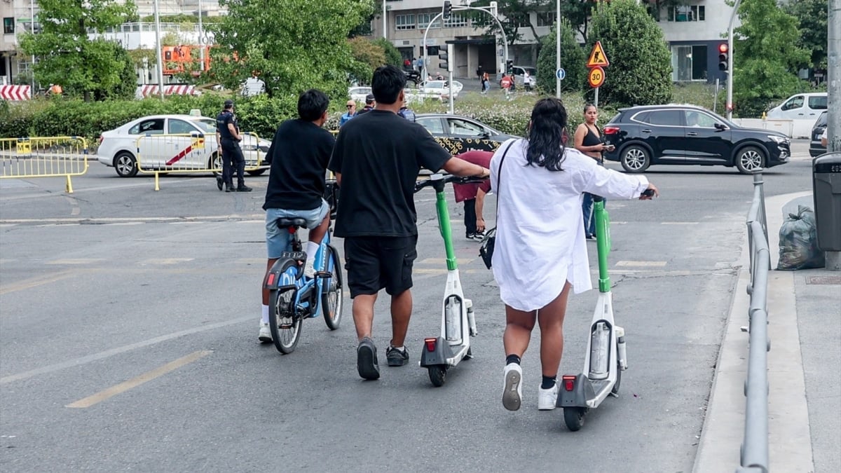 Dos personas circulan en patinete eléctrico en Madrid (España).