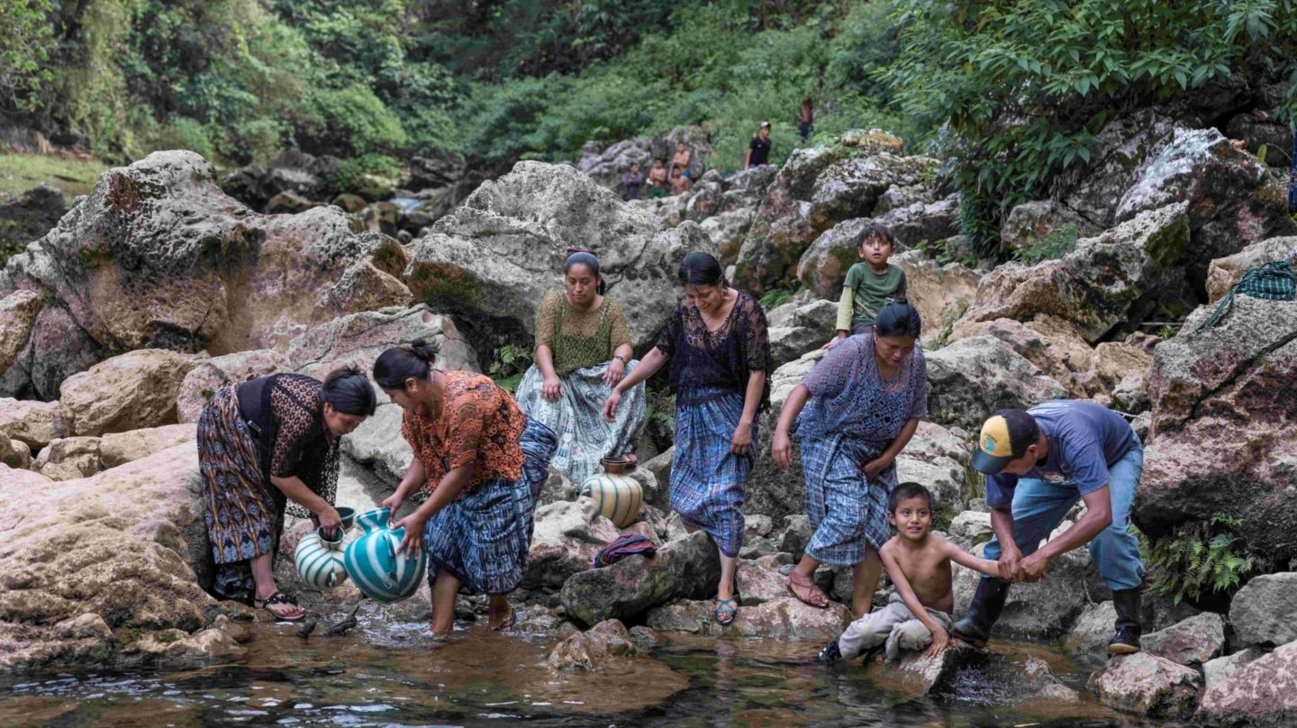 una mujeres limpian en un río
