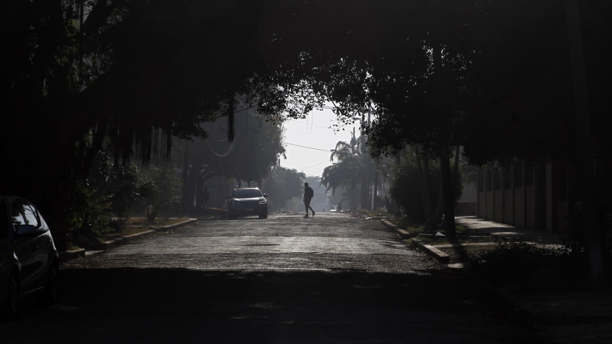 Una persona camina por una calle de La Habana al caer la tarde.