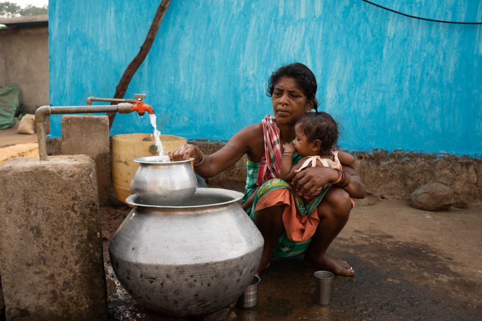 Gurubari Jani recoge agua en el nuevo grifo de su casa en Odisha, India.