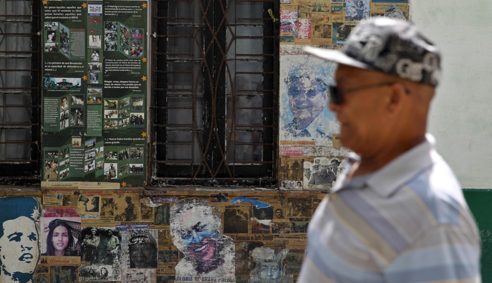 Un hombre pasa frente a carteles de propaganda en La Habana
