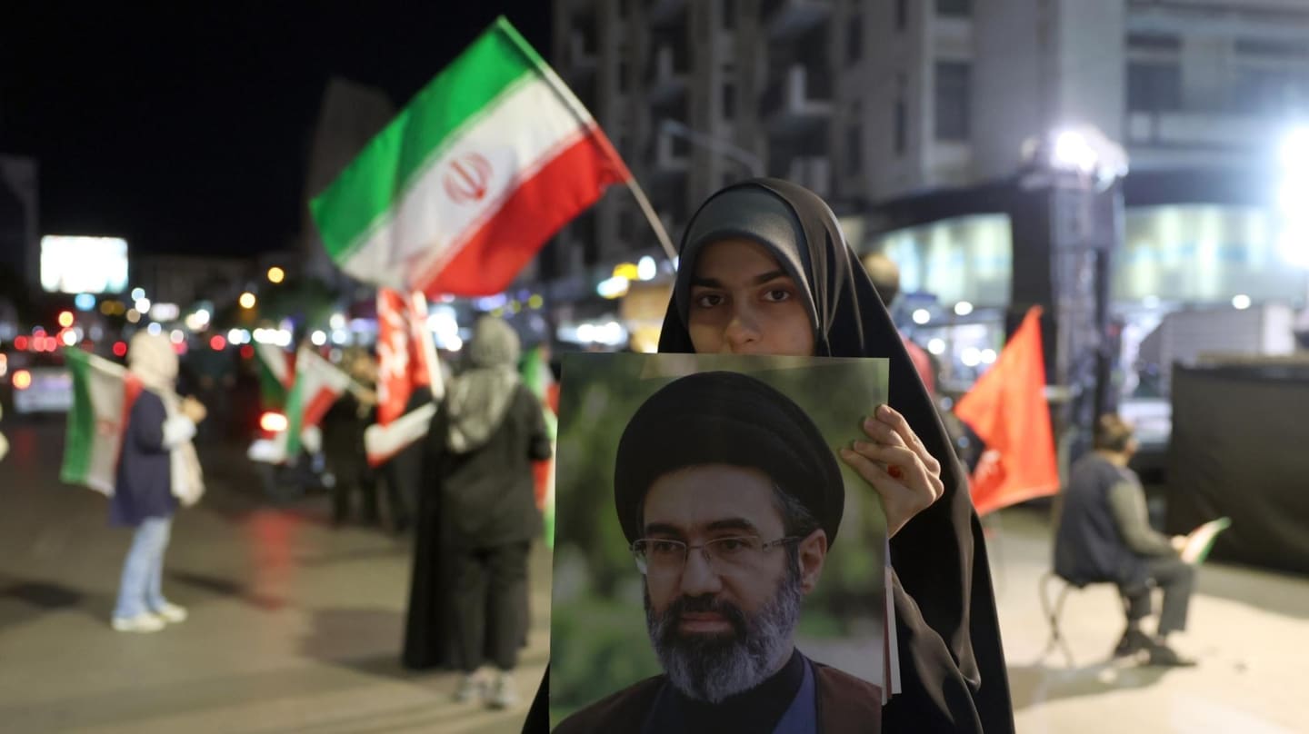 Una mujer sostiene una imagen del líder supremo iraní, el ayatolá Mojtaba Jamenei