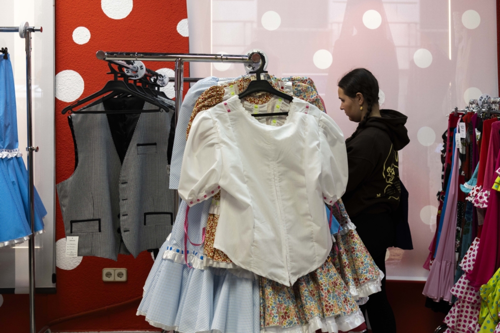 Una joven rebusca entre las prensas de ropa
