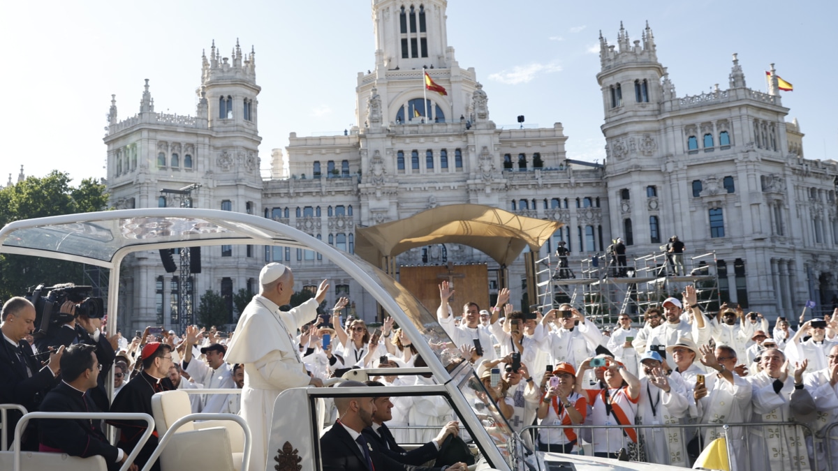 El papa León XIV saluda desde el papa móvil a su llegada a la plaza Cibeles para oficiar la misa del Corpus Christi.