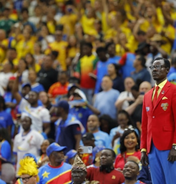 El aficionado de Congo conocido como Lumumba Vea posa como la estatua del líder de la independencia del país africano