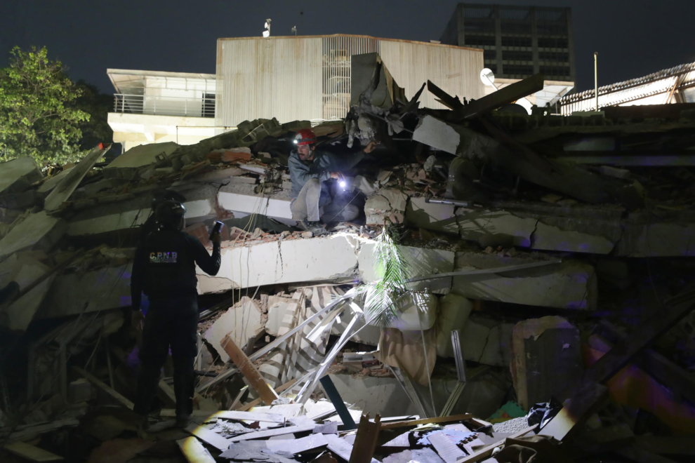 Integrantes de cuerpos de emergencia buscan víctimas.
