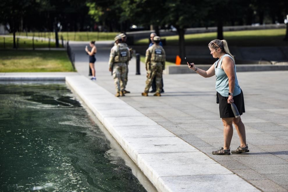 Una mujer saca fotos a las algas del Estanque Reflectante