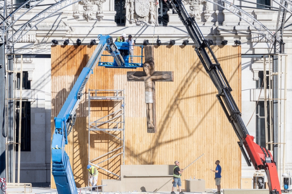 Varias personas trabajan en el montaje de escenarios para la Santa Misa del Papa León XIV en Cibeles
