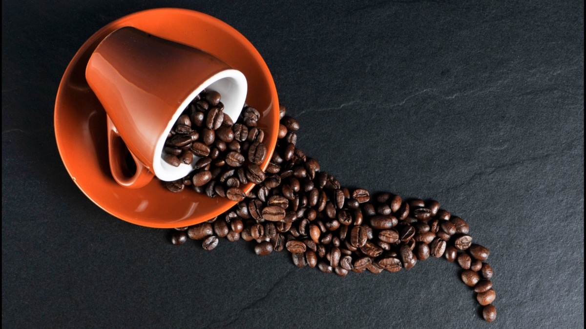 Taza y granos de café sobre una mesa
