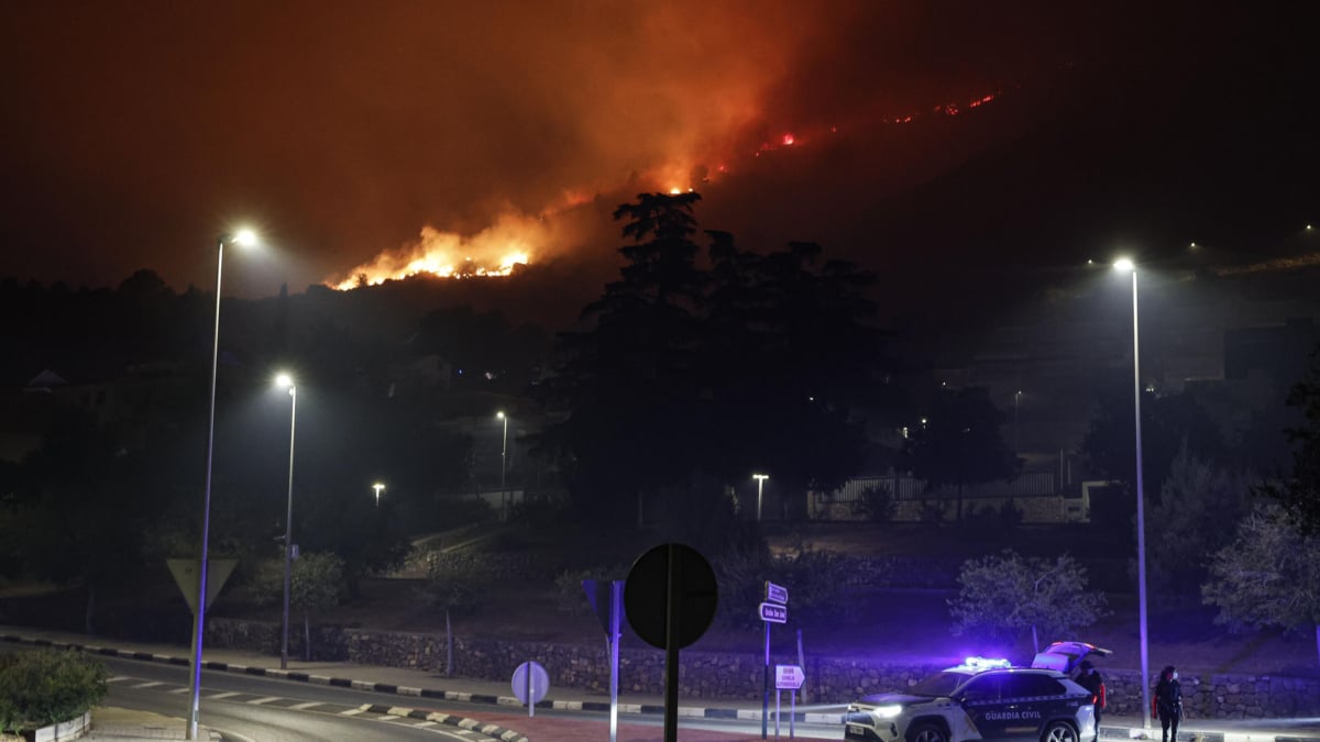 Agentes de la Guardia Civil en un cruce de La Vall d'Uixò a primera hora de hoy domingo donde continúa el incendio forestal declarado este sábado en este municipio castellonense.