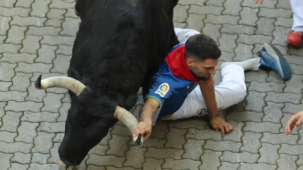 Un mozo cae ante un toro de Fuente Ymbro en el primer encierro de San Fermín.