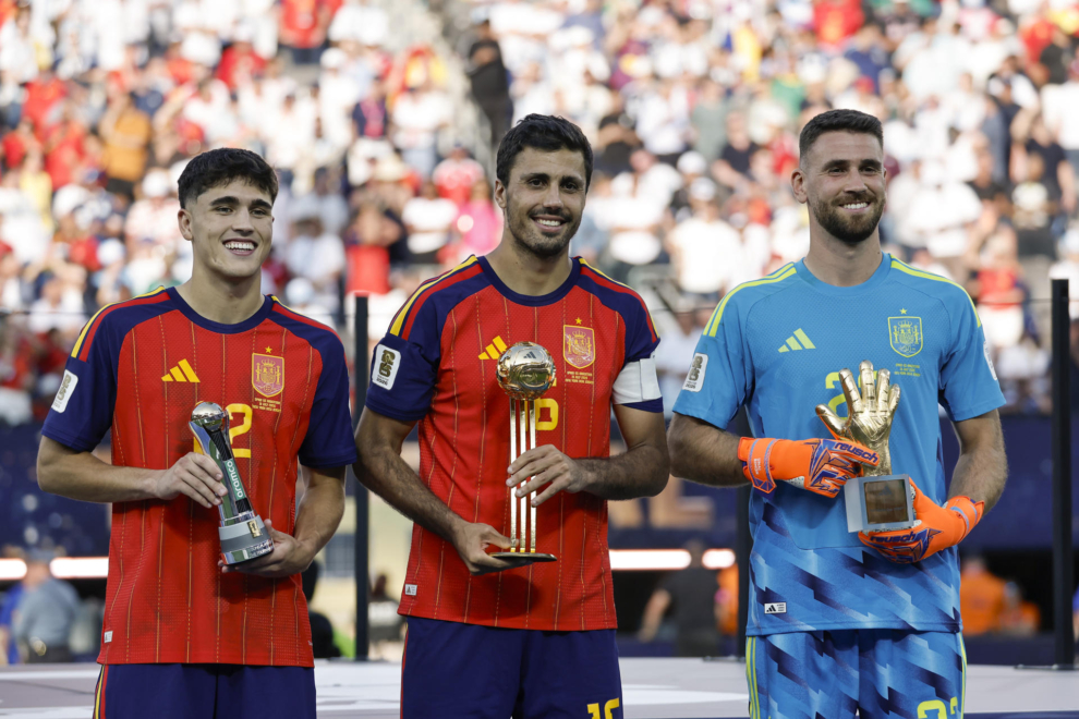 Pau Cubarsí (i), Rodri Hernández (c) y Unai Simón de España posan con sus trofeos en las premiaciones del Mundial de la FIFA 2026