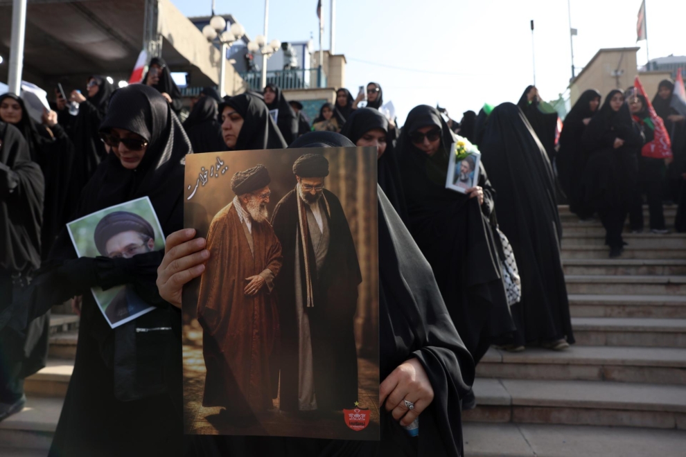 Una imagen sostiene una imagen del líder supremo iraní, el ayatolá Alí Jamenei, con su hijo y sucesor, Mojtaba Jamenei