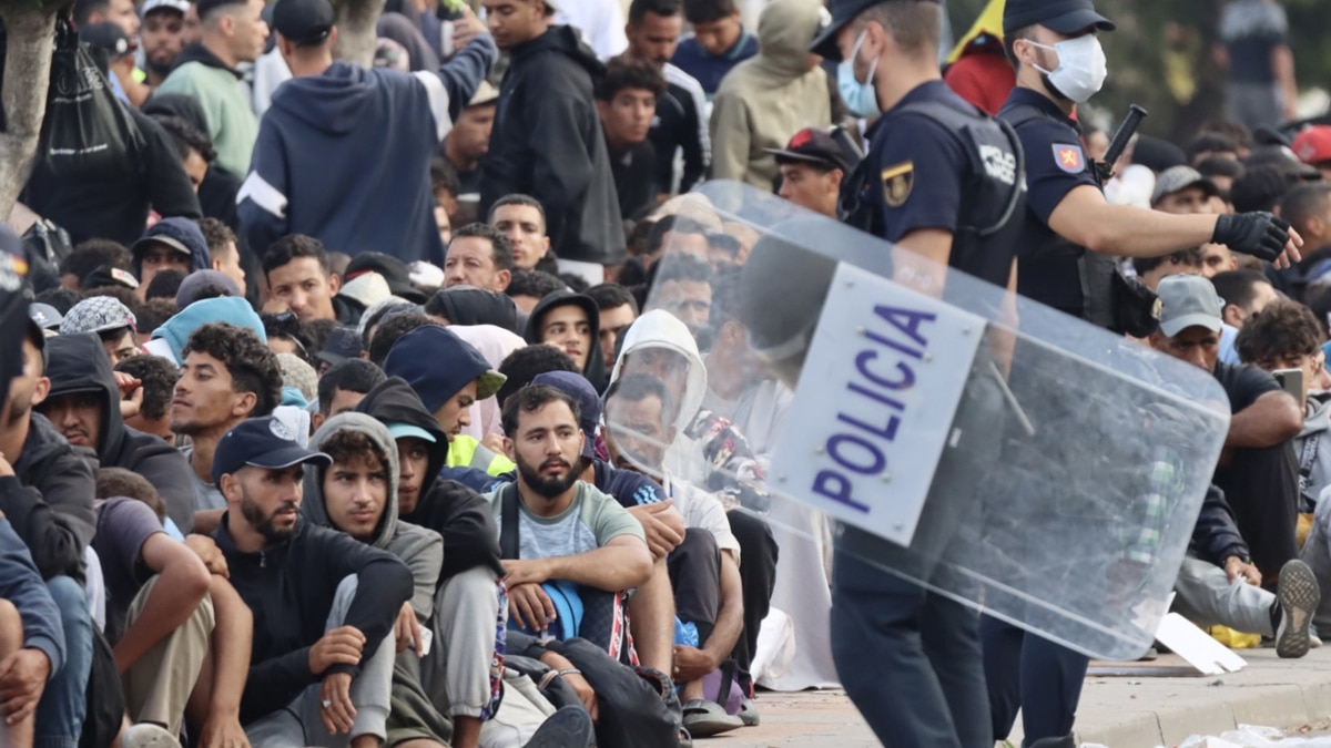 Migrantes frente a la explanada de embotellamiento de Loma Colmenar