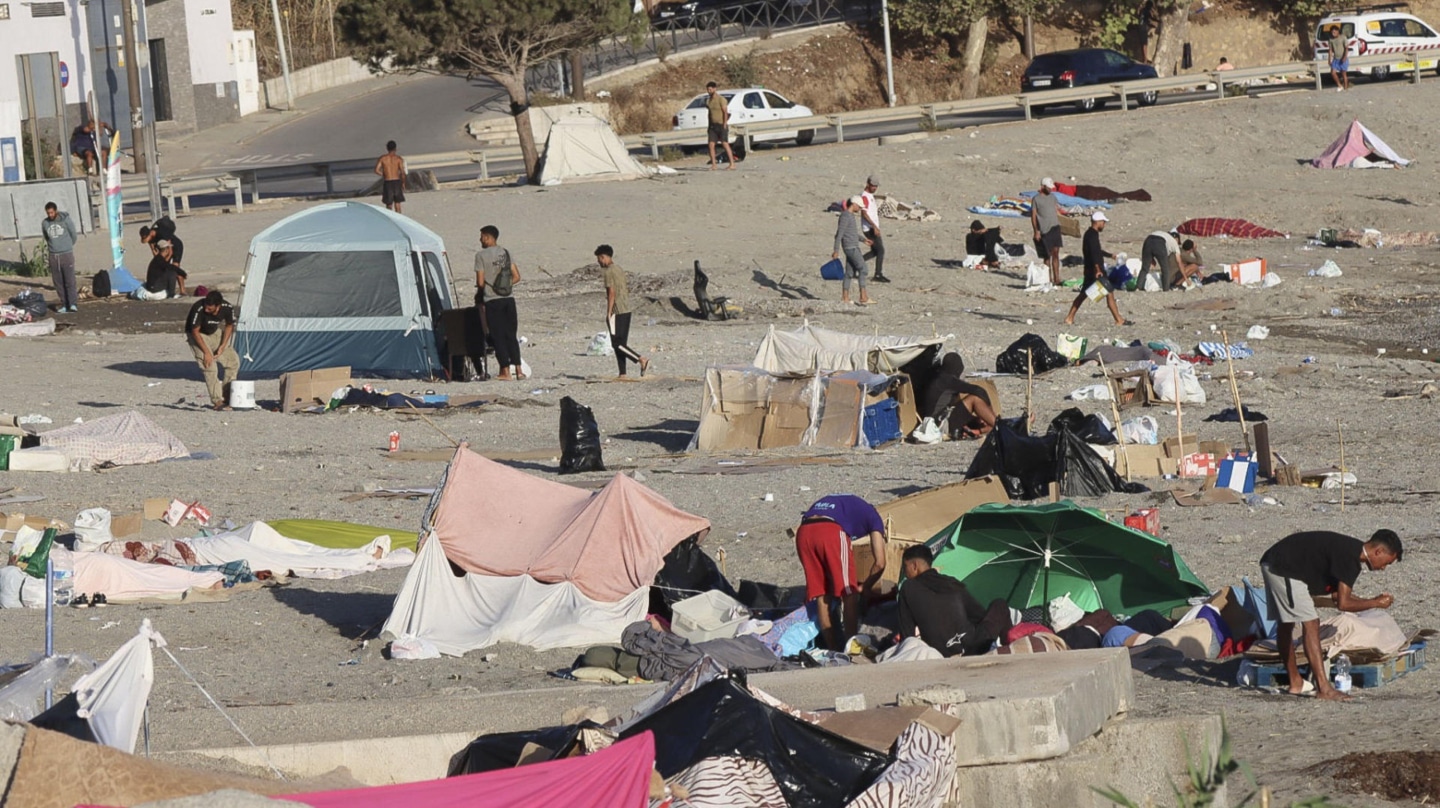 Algunos de los inmigrantes que continúan acampados en la playa de El Trampolín de Ceuta
