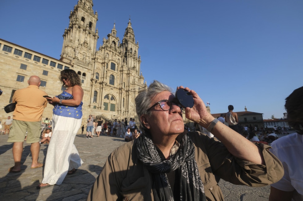 SANTIAGO DE COMPOSTELA, 12/08/2026.- Multitud de personas se dieron cita en la Plaza del Obradoiro para ver el eclipse solar, este miércoles en Santiago de Compostela. EFE/Xurxo Martínez