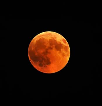 Imagen de una luna roja con el cielo nocturno
