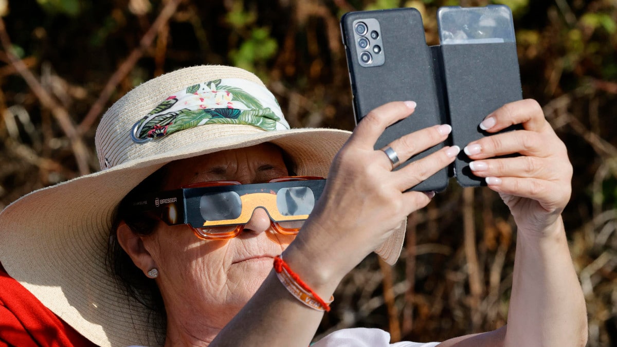 Una mujer observa el eclipse en Ferrol.