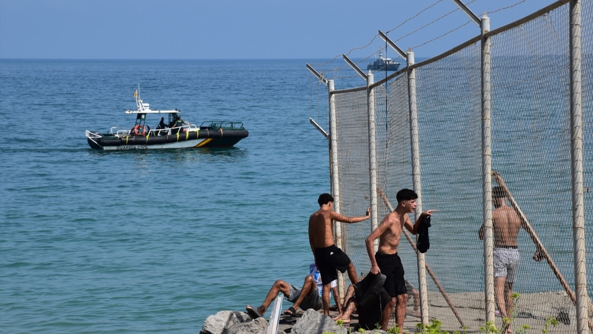 Varias personas cruzan la frontera, a 30 de julio de 2026, en Ceuta