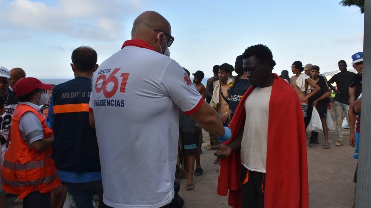 Cientos de personas migrantes reciben atención sanitaria de profesionales del INGESA y voluntarios de Cruz Roja, en la playa del Trampolín, a 7 de agosto de 2026, en Ceuta