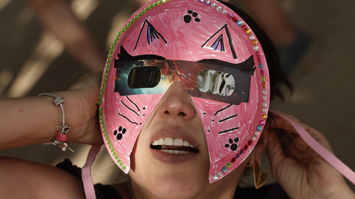 Una persona con una singular máscara con gafas integradas para ver el eclipse.