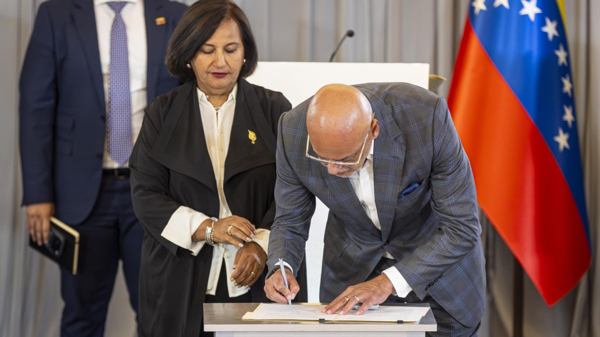 La opositora Dinorah Figuera y Jorge Rodríguez firman un documento tras la última sesión de la mesa de diálogo, e Caracas.