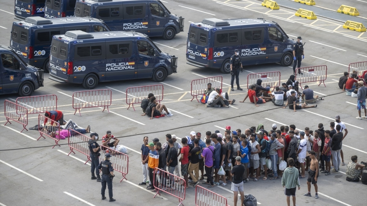 Migrantes desalojados de la playa del Trampolín de camino a ser reubicados, a 20 de agosto de 2026, en Ceuta